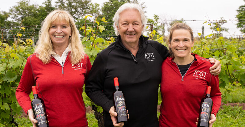 Owners Donna and Carl Sparkes with Head Winemaker, Gina Haverstock in the vineyard with bottles of Great Big Friggin' Red wine.