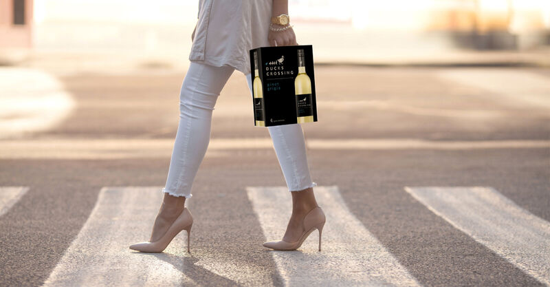 Woman in high heels in crosswalk carrying 4L Pinot Grigio